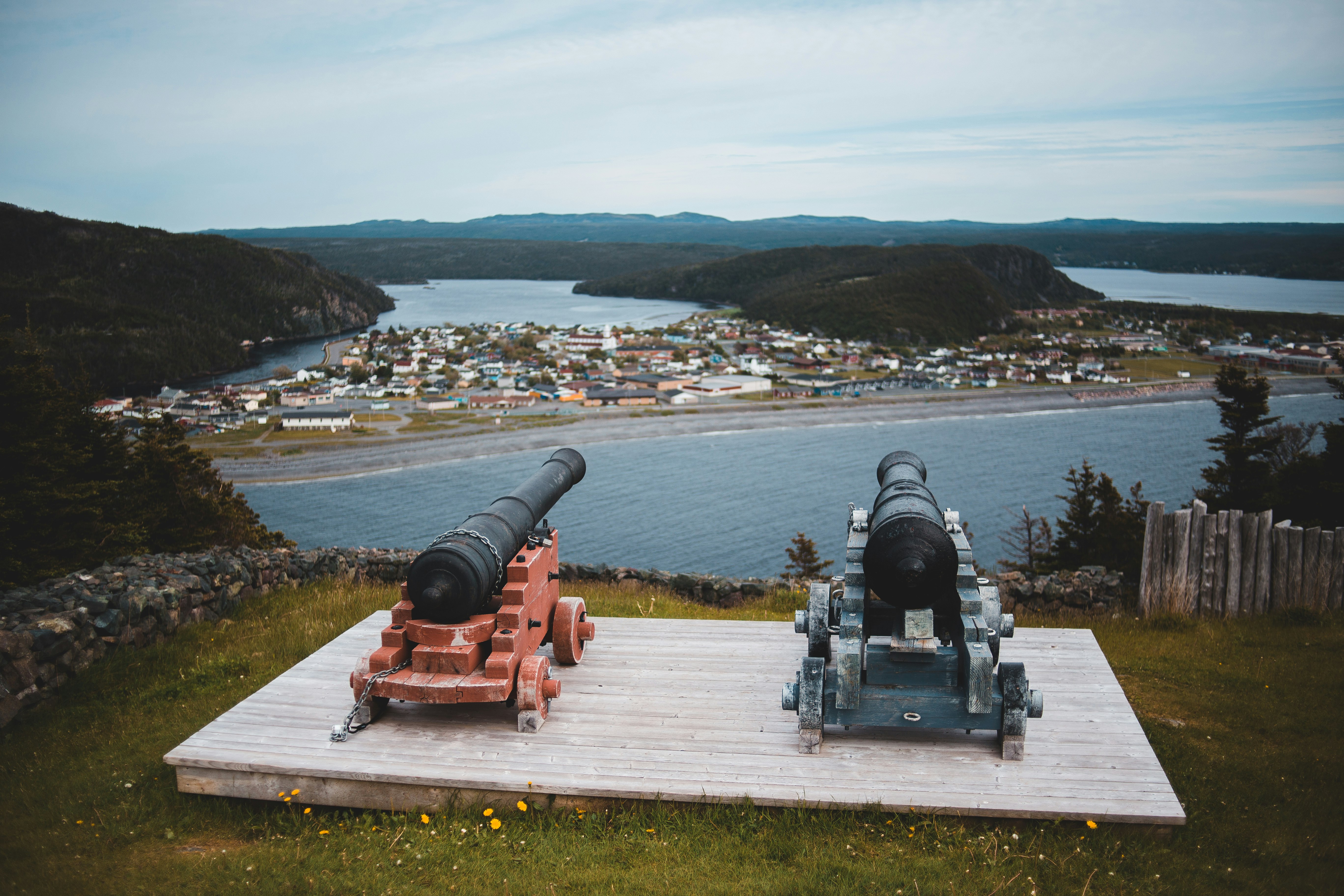 black and red canon on white concrete dock during daytime